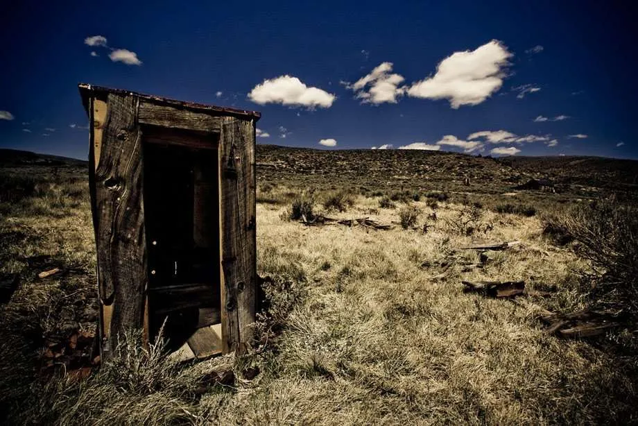 an outhouse in a barren field