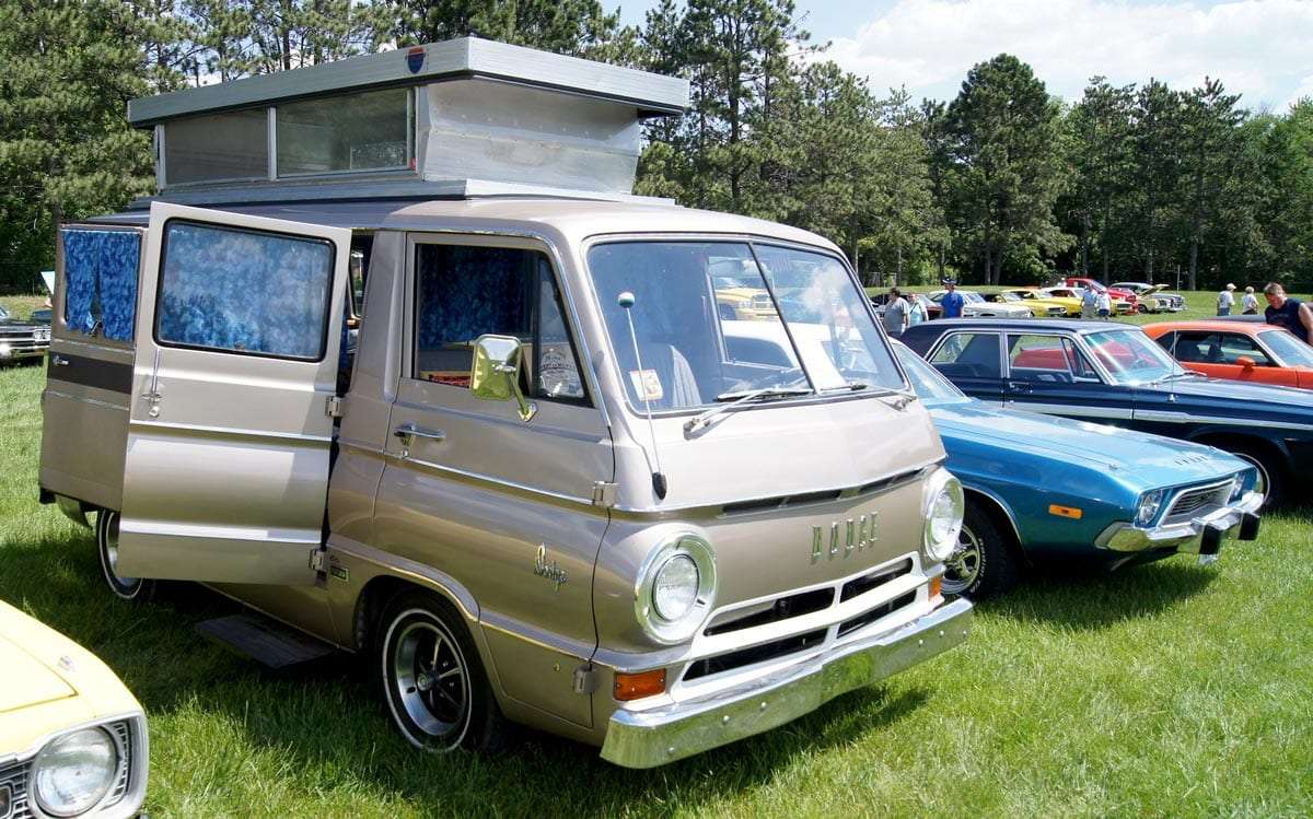 a champagne colored van from the 1960s with a pop top and other camping features