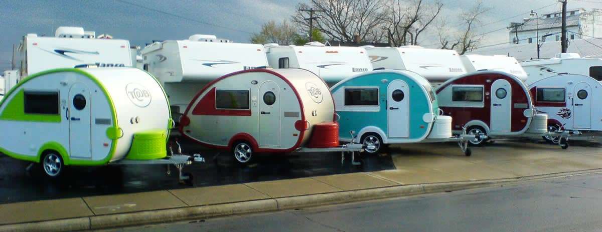 several small, teardrop-shaped trailers in a lot of RVs