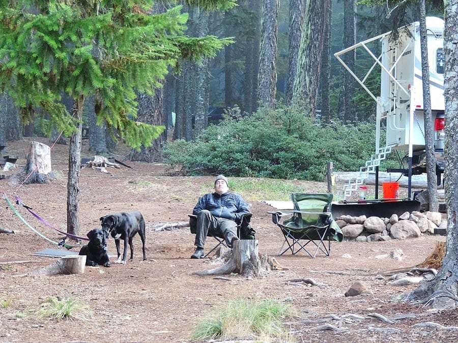 Un uomo, infagottato, si rilassa in una foresta