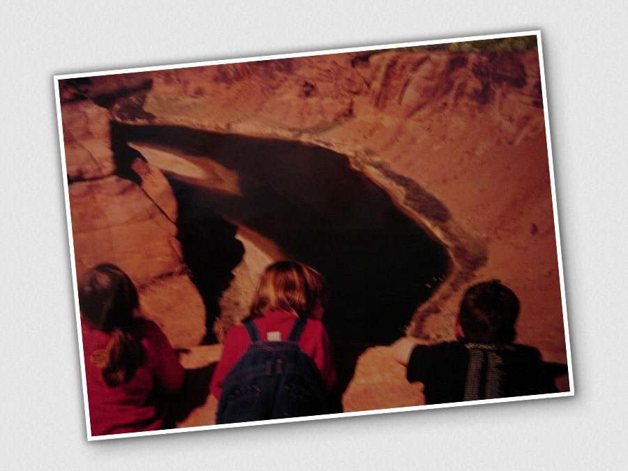 three young children in a photo taken before the Internet knew what to do with itself stare at a canyon