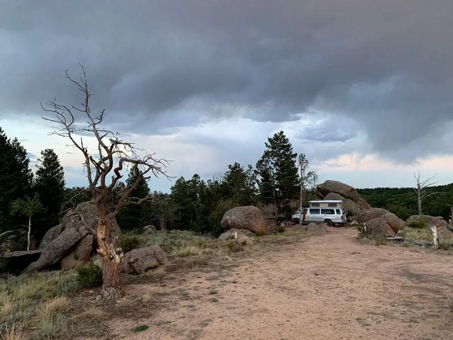 a van camping amongst large boulders