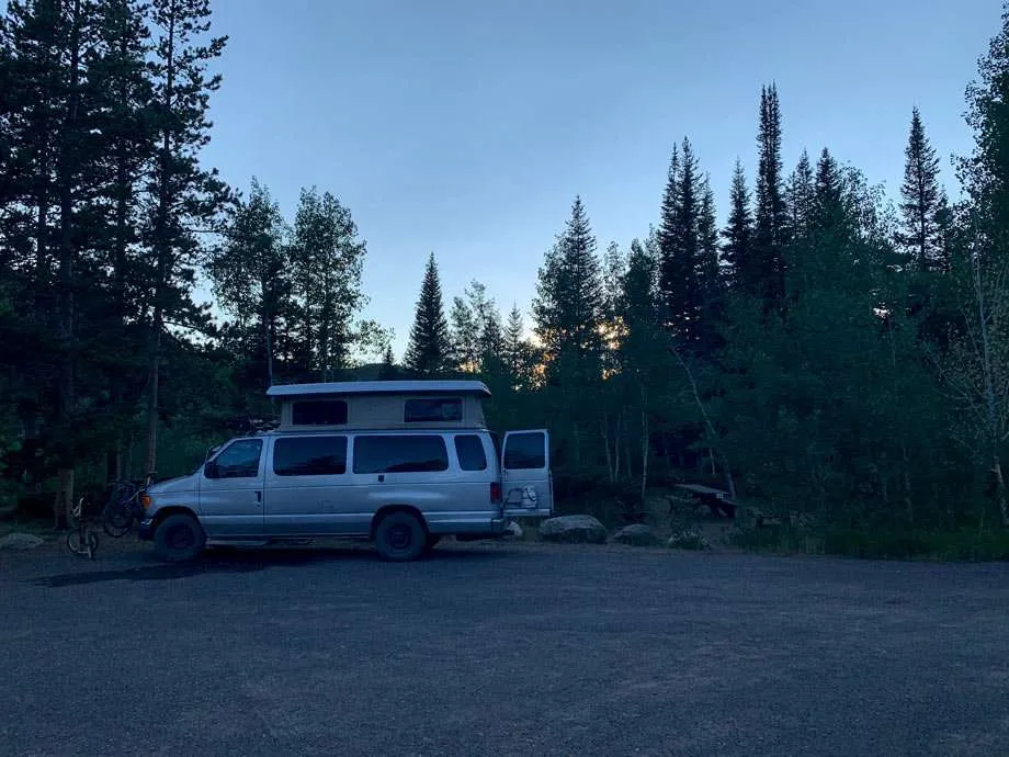 a van camping at a united states forest service campground