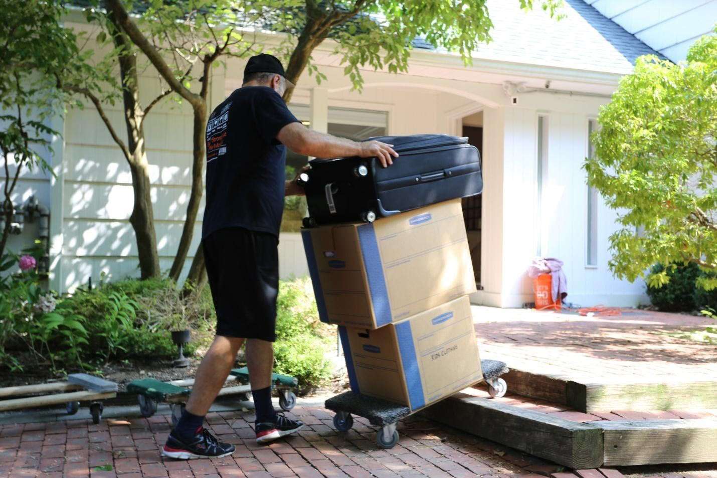 a man moving boxes into or out of a house