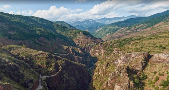 a majestic canyon, river and road stretching through nature's grandeur